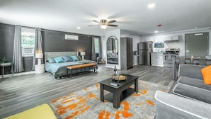 A modern apartment with a living area, kitchen, and dining space.