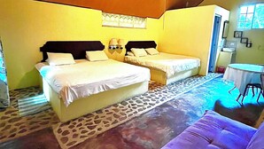 A bedroom with two beds, a ceiling fan, a small table, and a window. - Refugio Cariguana  (El Valle de Anton)
