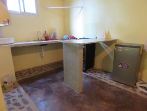 A compact kitchen with a countertop, a sink, and a refrigerator. - Refugio Cariguana  (El Valle de Anton)