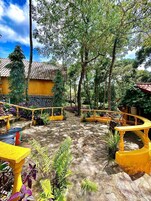 Un patio con barandillas amarillas, suelo de baldosas y diferentes plantas.