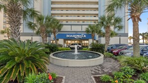 A hotel with a fountain, palm trees, and a parking lot. - Direct oceanfront, separate bedroom, full kitchen - rates lower than last year ! (Myrtle Beach)