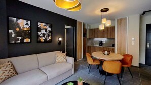 Una sala de estar moderna con un sofá, una mesa de comedor con sillas y arte abstracto en la pared.