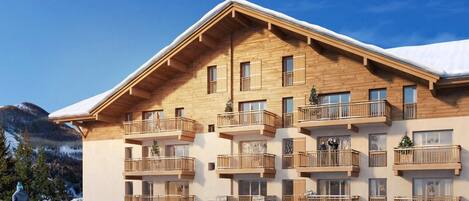 Un immeuble en bois à plusieurs étages, doté de balcons et d’une fondation en pierre, avec une piste de ski en arrière-plan.