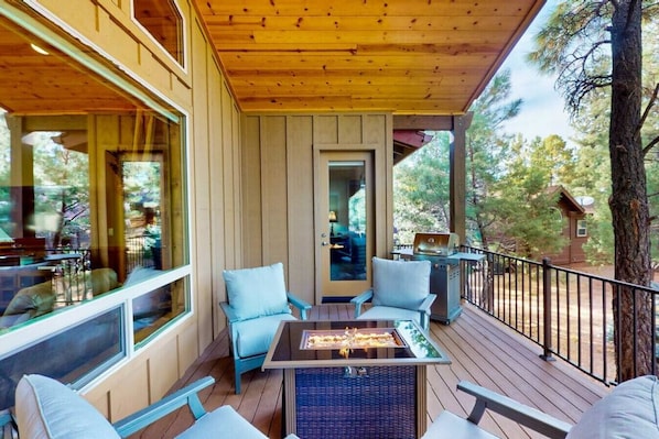 A covered outdoor patio with wicker furniture and a grill. - Pristine Torreon Cabin, Sleeps 6 (Show Low)