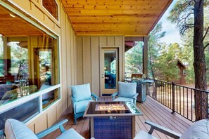 Eine überdachte Terrasse im Freien mit Korbmöbeln und einem Grill.