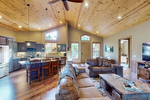 A spacious living area with a wooden ceiling, a kitchen with a large island, and a cozy seating area. - Pristine Torreon Cabin, Sleeps 6 (Show Low)