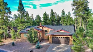 A two-story house with a garage, surrounded by a forested area. - Pristine Torreon Cabin, Sleeps 6 (Show Low)