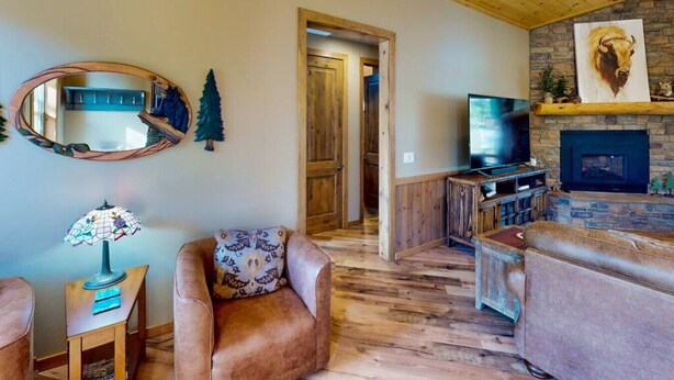 A cozy living room with a fireplace, a television, and a comfortable seating area. - Pristine Torreon Cabin, Sleeps 6 (Show Low)