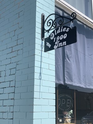 A black sign with white lettering for 'Oldies 1900 Inn' pointing to a building entrance. - Beach-themed rental with many activities within walking distance. (Assumption)