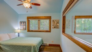 A bedroom with a bed, a ceiling fan, a window, and wall art. - Barnes on Boundary Unit A (West Yellowstone)