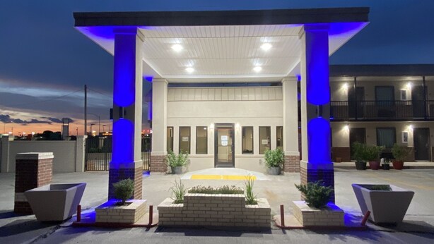 A modern building with a covered entrance, columns, and a well-lit facade. - Hotel 81 El Reno (El Reno)