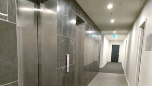 Un pasillo con ascensores y una puerta al final.