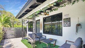 Un espace extérieur aménagé avec une pergola, un panneau d’accueil et un panneau indiquant « Entrée ».