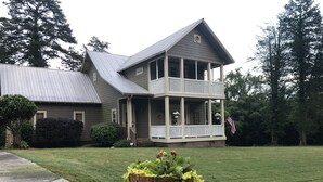 A two-story house with a porch and a large front yard. - Craftsman style family gathering home close to Guntersville (Scottsboro)