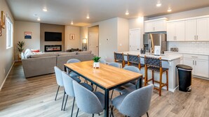 A modern apartment with a dining area, kitchen, living room, and a fireplace.