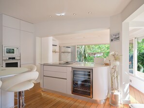 Una cocina moderna con una isla central, electrodomésticos integrados y vistas al exterior.
