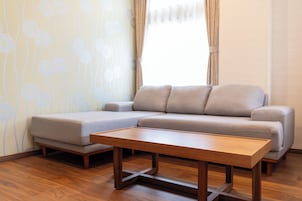 Una sala de estar moderna con un sofá modular, una mesa de centro de madera y un papel tapiz estampado.
