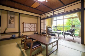 A traditional Japanese-style room with tatami flooring, a low wooden table, and seating. - Koubounoyu Honten (Izunokuni)