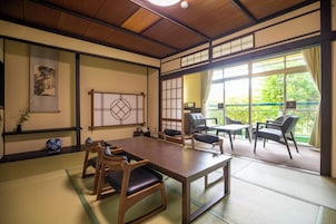 Una habitación tradicional japonesa con suelo de tatami, una mesa de madera baja y asientos.