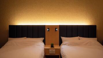 A double bed with a headboard, a bedside table with a lamp, and a small plant.
