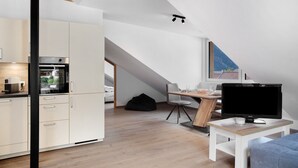 Un loft moderno con cocina, comedor y un amplio ventanal con vistas a la montaña.
