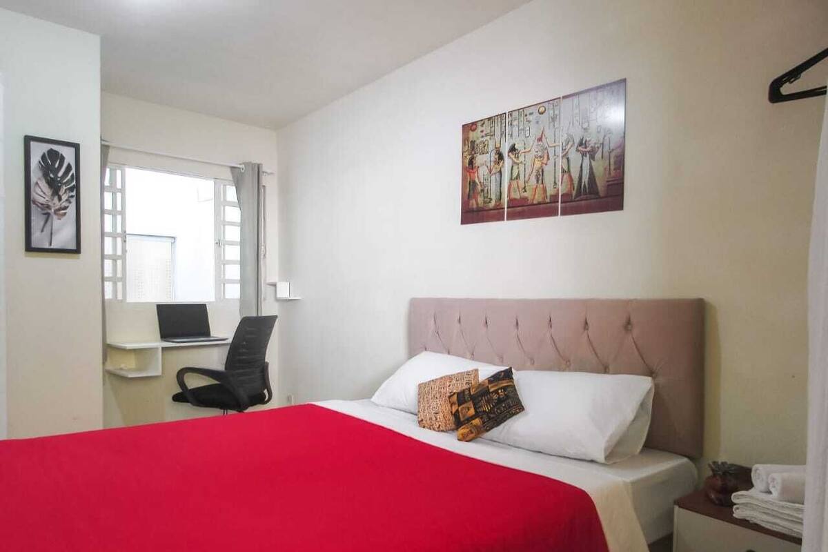 Un dormitorio con una cama, un escritorio y una silla.