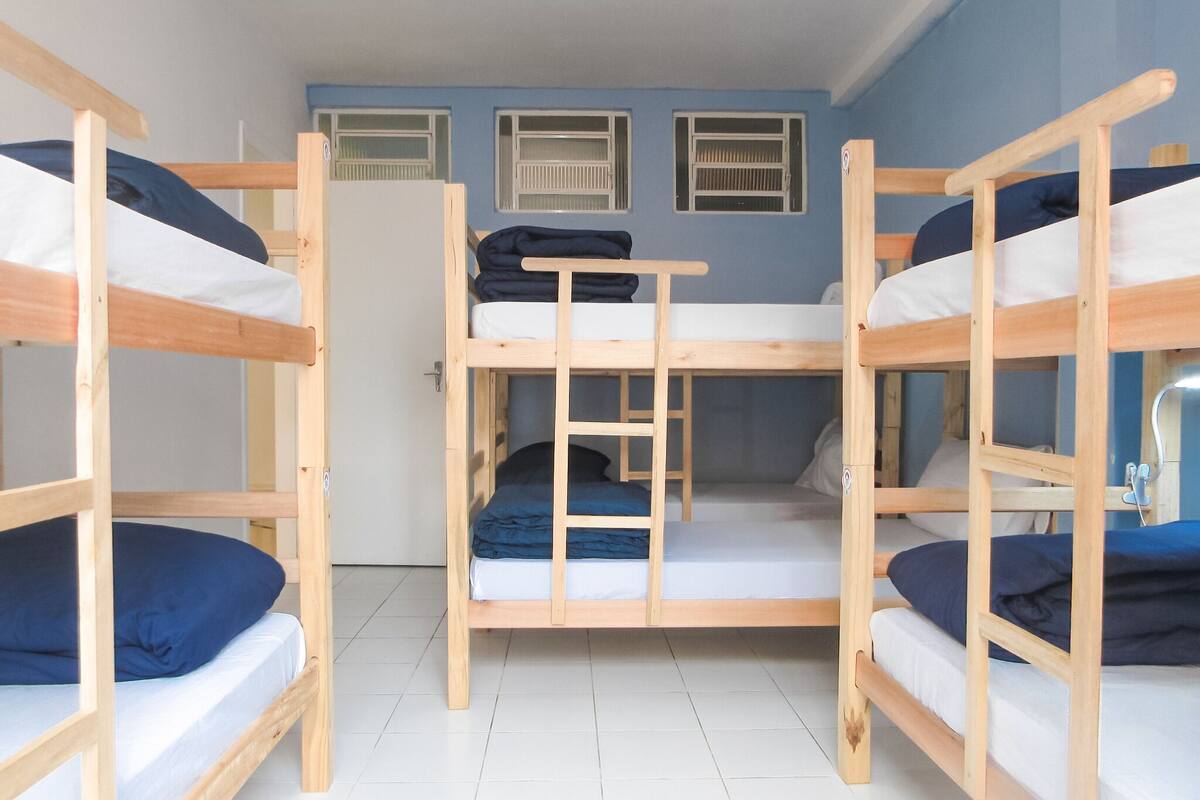 Un dormitorio con literas, una puerta y una ventana.