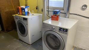 Two front-loading washing machines in a laundry room with a window and a door. - Duplex Apartment Walking Distance to Downtown Wyandotte  (Wyandotte)