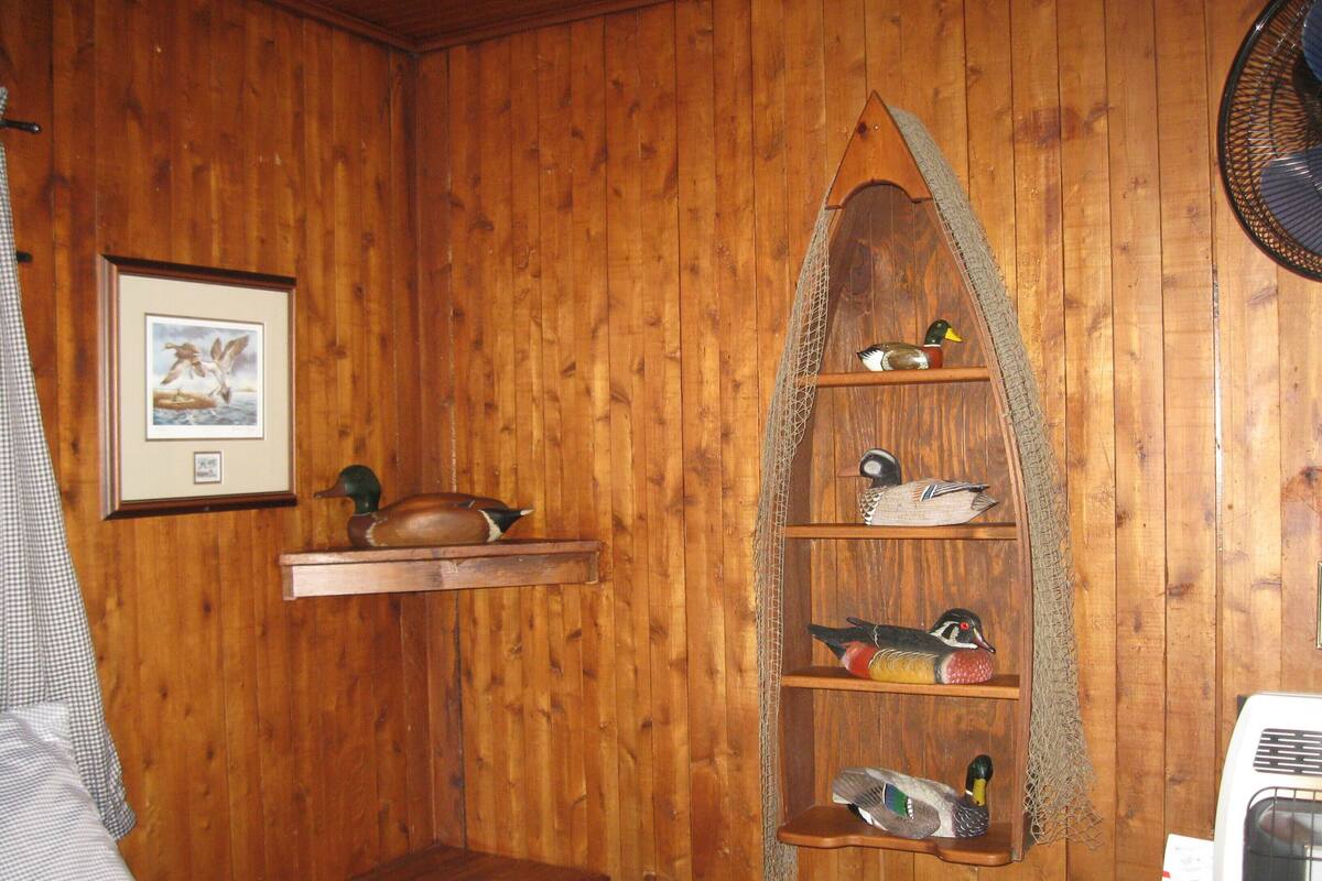 A wooden interior with a shelf displaying various bird figurines.