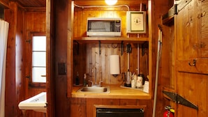 Une cuisine compacte équipée d’un four à micro-ondes, d’un évier et d’un petit réfrigérateur.