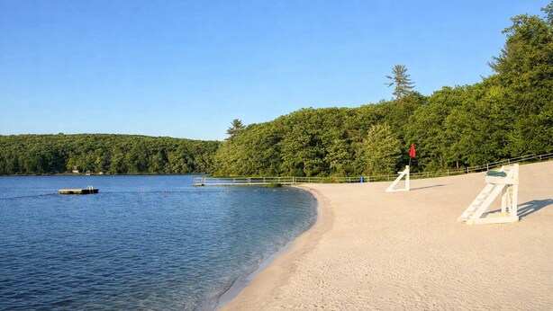 A beach with clear water, a dock, and a lifeguard tower. - Poconos Getaway / Lake, Pools, Fire Pit & Ski Big Bear / Sleeps 10 (Lackawaxen)