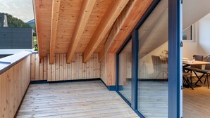 Un interior moderno con vigas de madera, una puerta de cristal y un comedor.