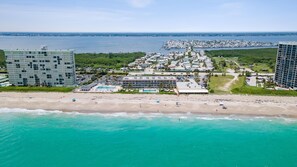 Un complejo turístico frente a la playa con una piscina grande y varias construcciones.
