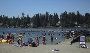 Une plage où l’on peut se baigner et bronzer, une jetée et un panneau indiquant l’absence de sauveteur.