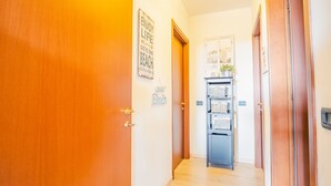 Ein Flur mit Holztüren, einem an der Wand befestigten Regal mit Körben und einem Willkommen-Schild.