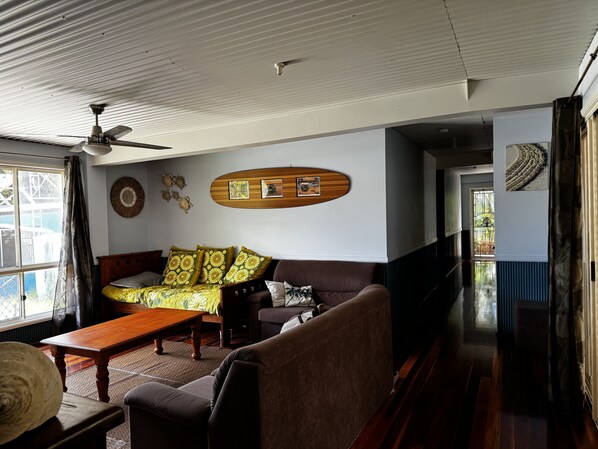 A living room with a sofa, a wooden coffee table, and a ceiling fan.