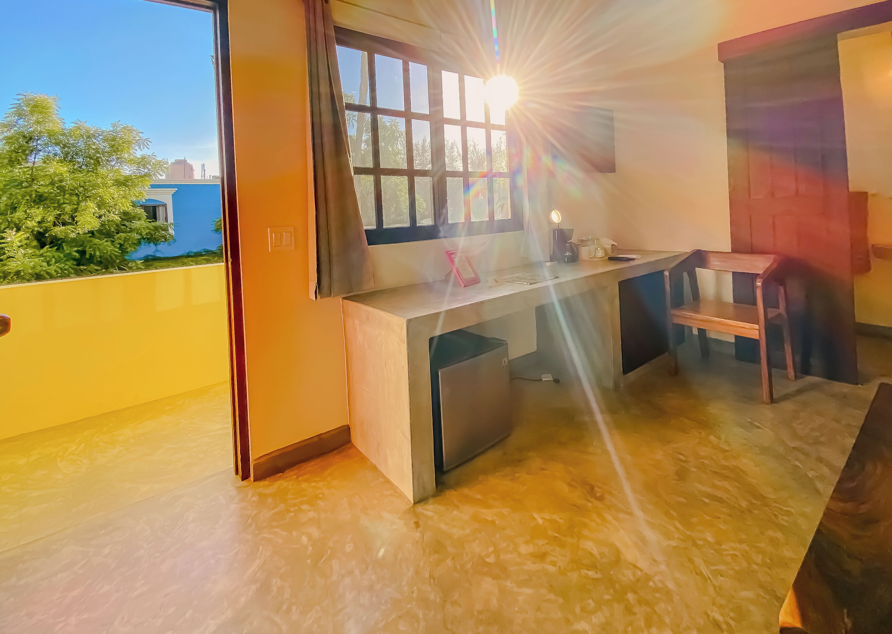 Una cocina con ventana, un lavabo y una silla.