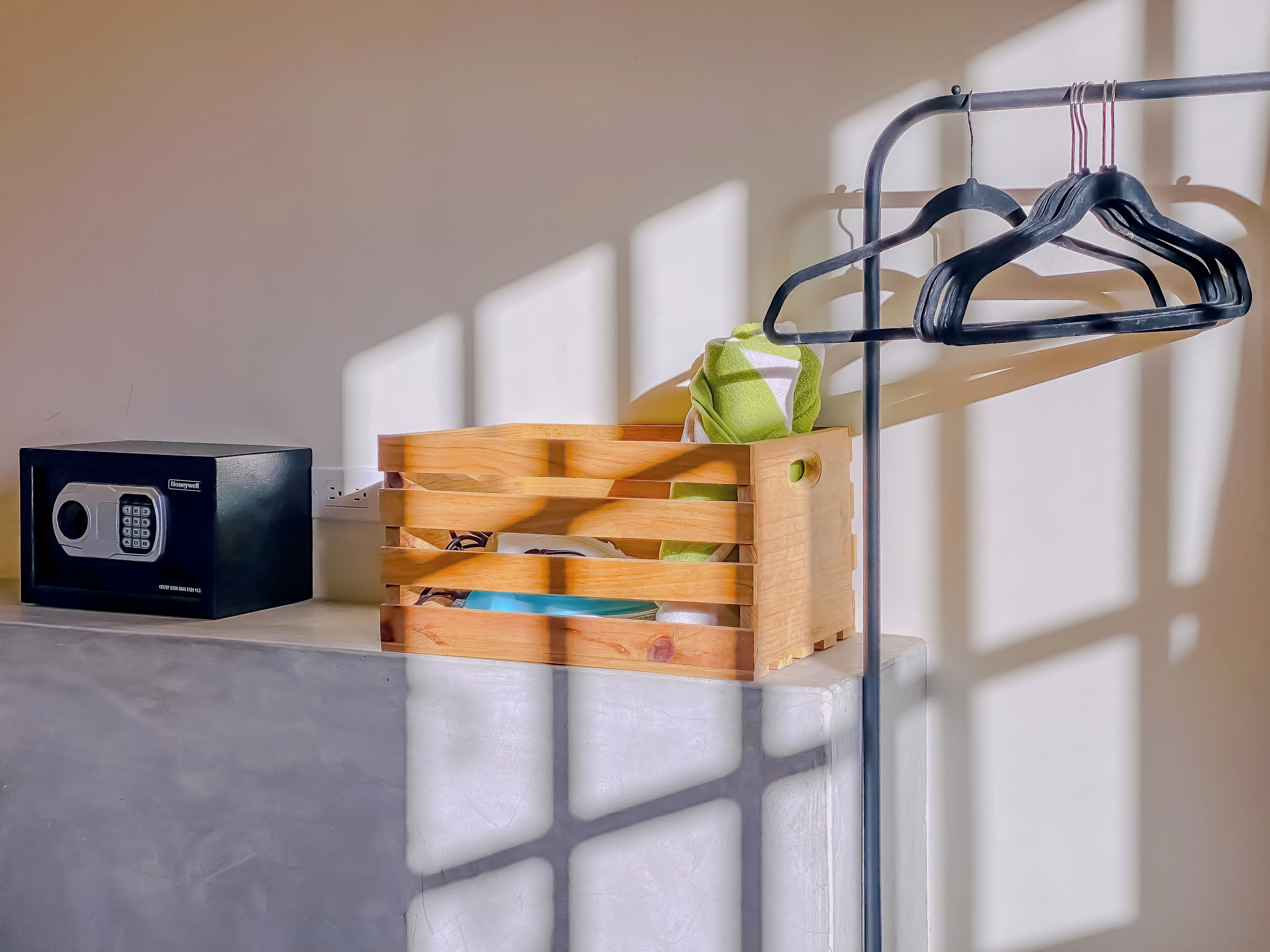 A wooden crate with a green towel and a black radio on a white surface.