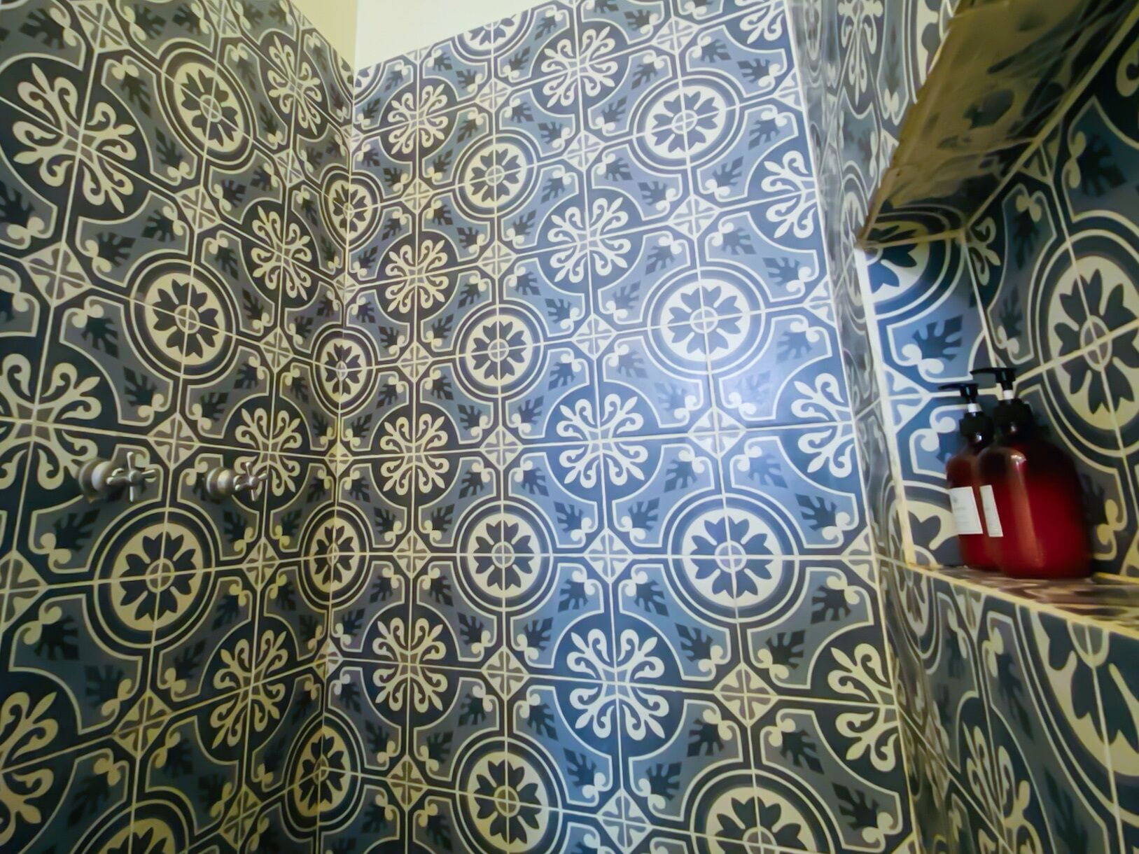 Un baño con azulejos blancos y azules de diseño elaborado.
