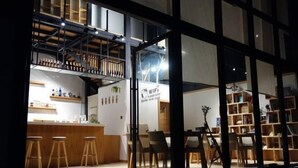 A modern interior with a bar area, seating, and a staircase. - Mumu Hotel (Dali City)