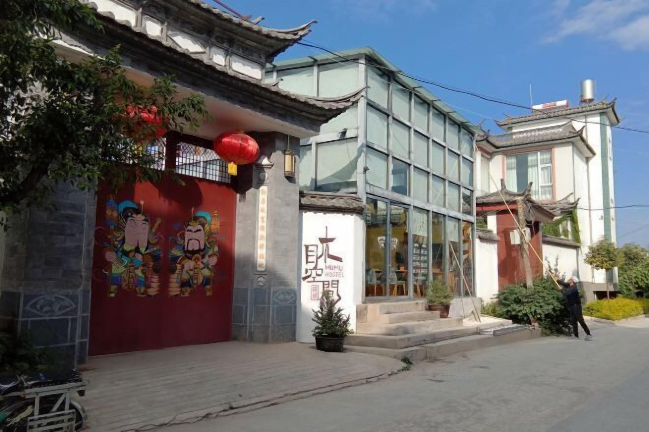 A traditional building with a red wall and a modern glass extension.