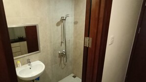 Ein Badezimmer mit Waschbecken, Spiegel und Dusche.