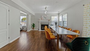 Un comedor con una mesa larga, varias sillas y una chimenea.