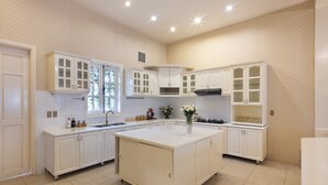 A spacious kitchen with white cabinetry, a central island, and a large window providing natural light.