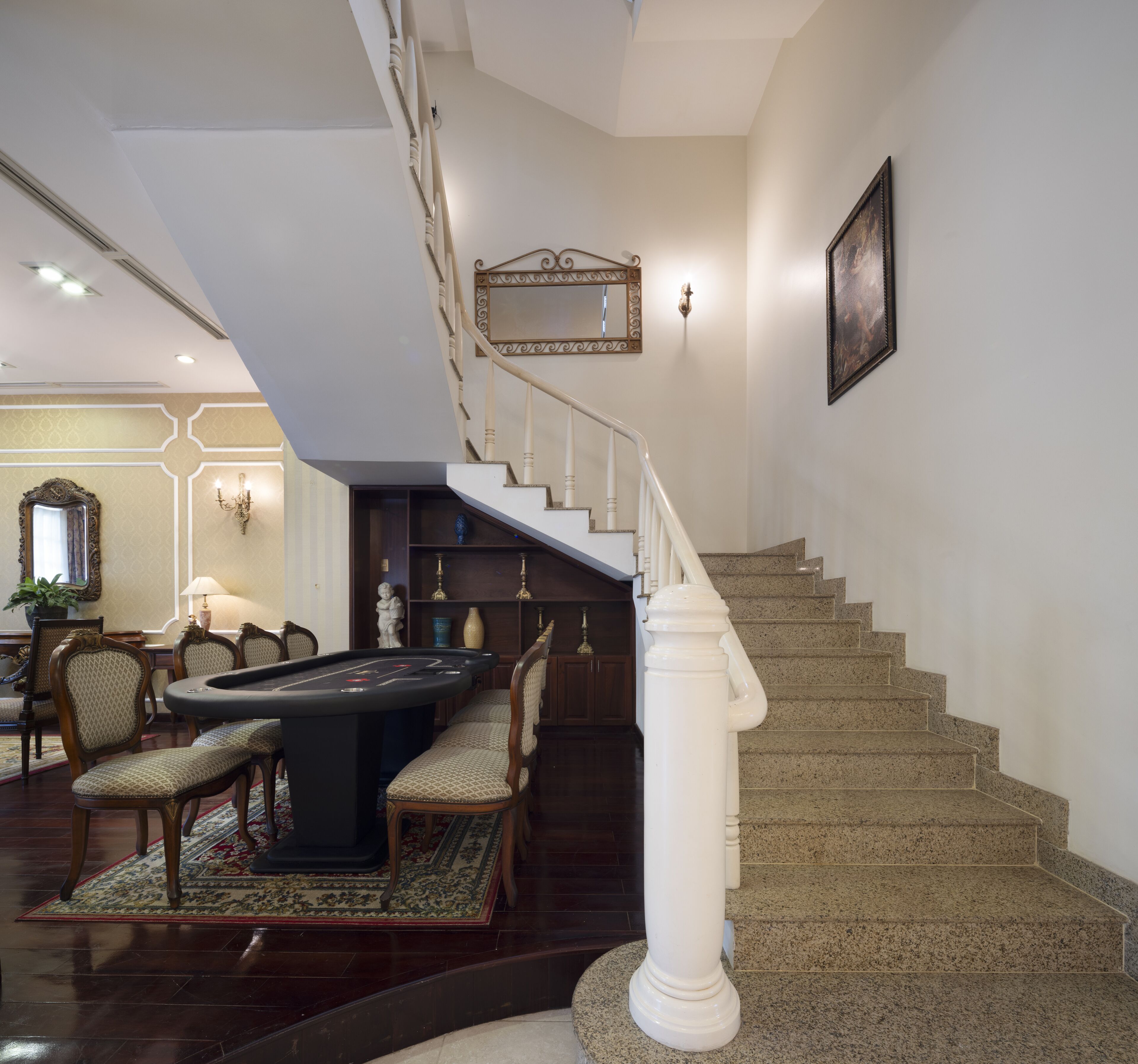Eine imposante Treppe mit weißer Brüstung, die zu einer zweiten Etage führt.