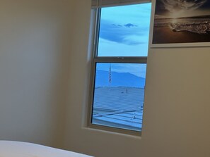 A room with a window overlooking a mountain and a flag.