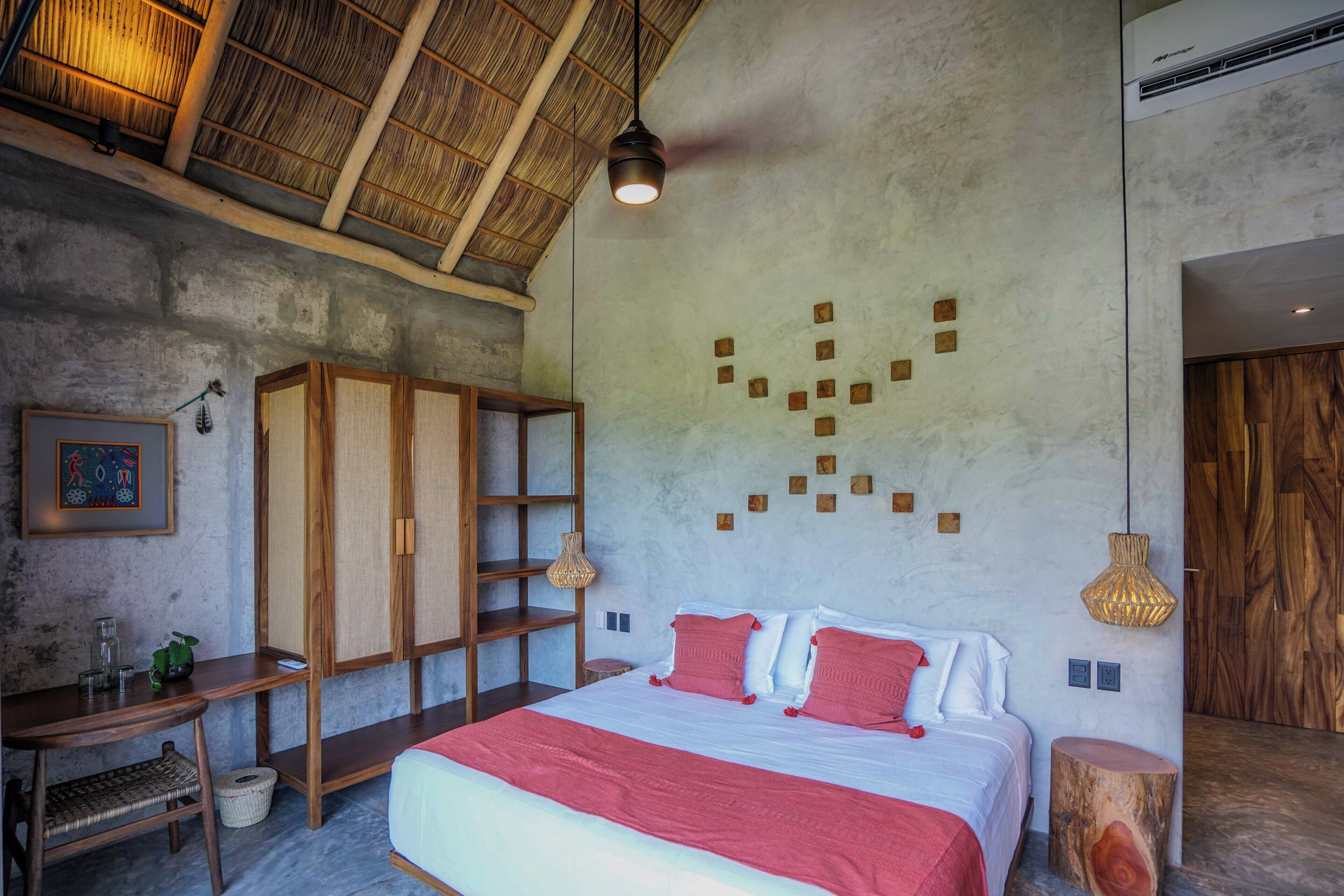 A bedroom with a large bed, wooden furniture, and a unique wall design.