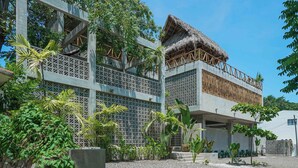 A modern building with a thatched roof, surrounded by lush greenery.