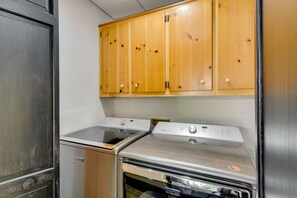 A kitchen with a stainless steel oven, a built-in dishwasher, and wooden cabinets above the appliances.