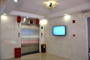 An elevator with a digital display, a television mounted on the wall, and a red lantern hanging above it. - Yiru Express Apartment Hotel（Shantou's long corridor on the seaside) (Shantou)